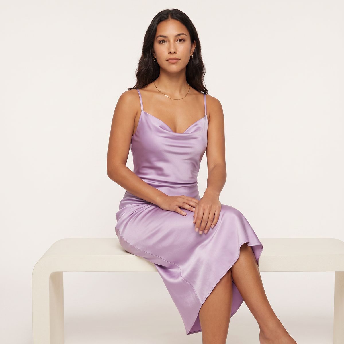 Model seated wearing lilac satin slip midi dress