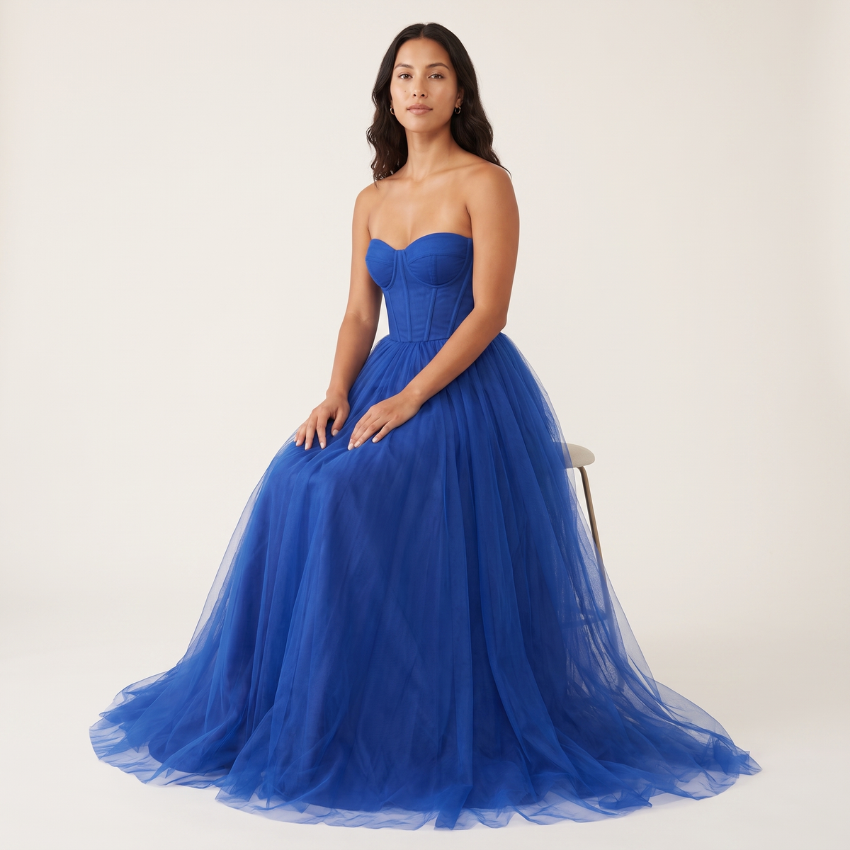 Model seated wearing cobalt blue tulle corset ball gown